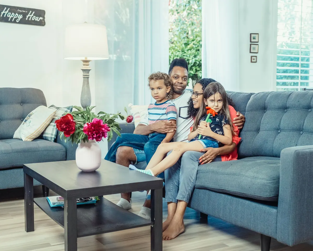 Family relaxing together on a sofa in a bright, modern living room
